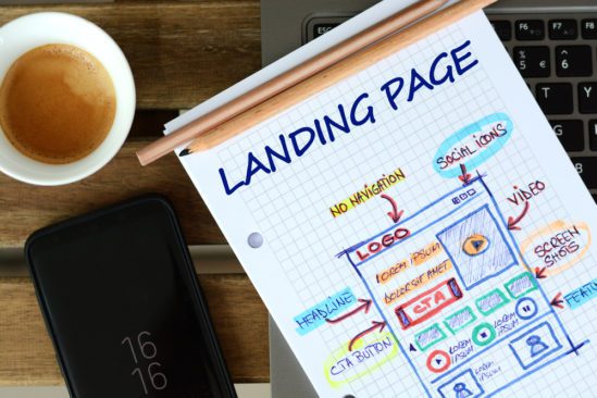 Piece of paper with coffee on the side with "Landing Page" and description of one on the piece of paper